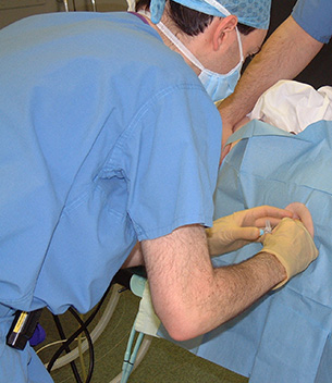 An anaesthetist performing a lumbar plexus block on a patient before hip replacement surgery.